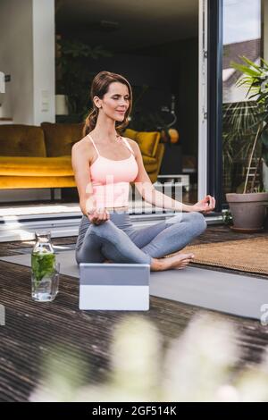 Frau, die Yoga auf der Übungsmatte auf der Terrasse macht Stockfoto