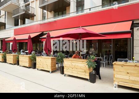 Ein Paar sitzt unter dem Sonnenschirm im Straßencafe Stockfoto