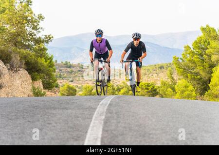 Reife männliche Athleten, die auf der Straße fahren Stockfoto