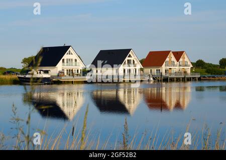 Häuser in Deutschland, Niedersachsen, Harlesiel, Tilt am Fluss Harle Stockfoto