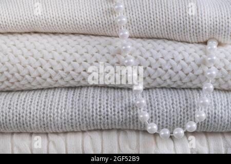 Warme, kuschelige Kleidung mit verschiedenen Strickmustern in Nahaufnahme. Winterhintergrund. Stockfoto