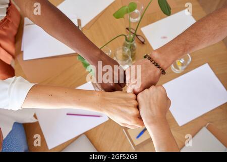 Männliche und weibliche Mitarbeiter geben Faustfallen am Arbeitsplatz Stockfoto