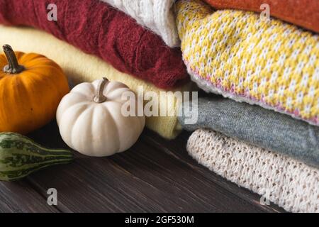 Herbstkomposition mit verschiedenen Strickpulvern und Kürbissen. Saisonaler Hintergrund. Stockfoto