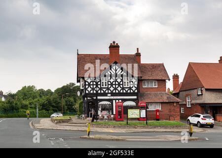 Port Sunlight, Wirral, Großbritannien: TUDOR Rose Tea Rooms, Kreuzung von Greendale Road und Park Road, mit roten Telefonzellen im K2-Design. Stockfoto