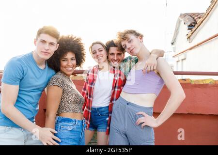 Lächelnde, multiethnische Freundinnen und Freundinnen auf der Terrasse Stockfoto