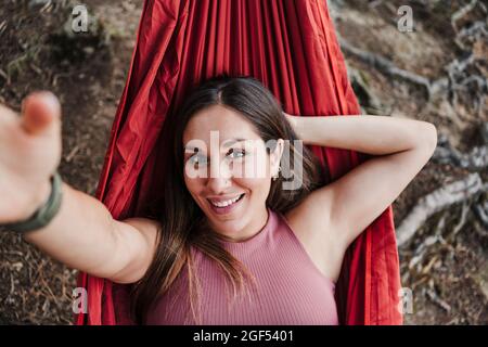 Schöne Frau, die sich in der Hängematte im Wald entspannt Stockfoto