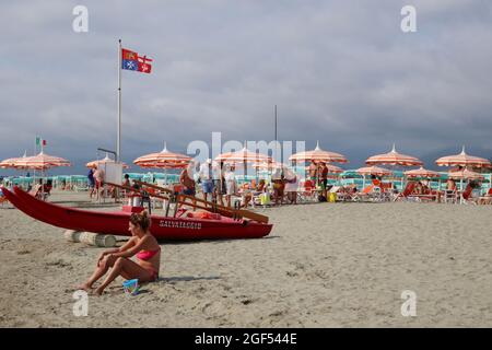 Versilia, Italien. August 2021. Ein Strand in der Versilia, Toskana, Italien, am 22. August 2021. Die Toskana hat mehr als 400 km (250 Meilen) Küste. Der nördliche Teil der Insel, die Versilia genannt wird, hat einen breiten und langen Sandstrand, der kilometerweit von Marina di Carrara bis Torre del Lago Puccini reicht und glamouröse Resorts wie Forte dei Marmi, Marina di Pietrasanta und Viareggio umfasst. Hunderte von Badeanstalten bedecken die Küste, mit Apuanischen Alpen, einer sehr beeindruckenden Bergkette im Hintergrund.(Elisa Gestri/Sipausa) Quelle: SIPA USA/Alamy Live News Stockfoto