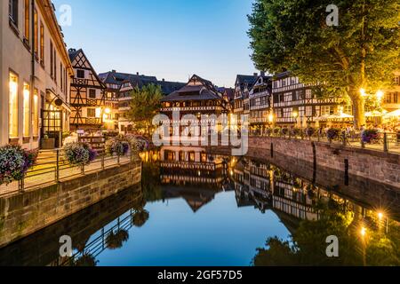 Frankreich, Bas-Rhin, Straßburg, Langzeitbelichtung von Fachwerkhäusern, die sich in Petite France in der Abenddämmerung am Flusskanal spiegeln Stockfoto