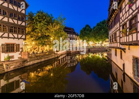 Frankreich, Bas-Rhin, Straßburg, Langzeitbelichtung von Fachwerkhäusern, die sich in Petite France in der Abenddämmerung am Flusskanal spiegeln Stockfoto