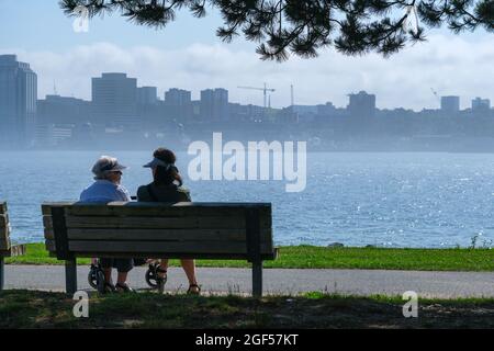 Dartmouth, Kanada - 10. August 2021: Menschen sitzen auf der Bank in Dartmouth, Nova Scotia, Kanada Stockfoto