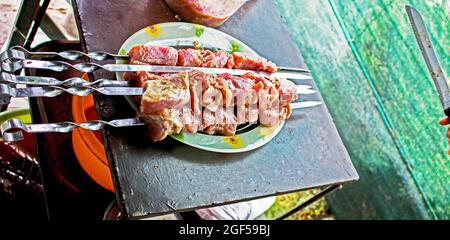 Rohe, saftige Fleischscheiben mit Zwiebel auf den Spiessen. Nahaufnahme. Stockfoto