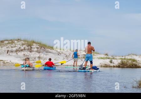 Kajaks und Paddle Boards paddeln entlang eines Küstendünensees, der vom Western Lake im Grayton Beach State Park, Florida, USA, abfällt Stockfoto