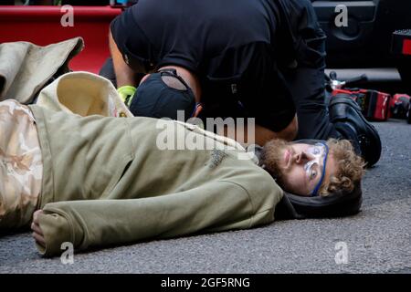 London, Großbritannien, 21. August 2021:- Spezialbeamte der Polizei verwenden Schneidausrüstung, um das Aussterben zu beseitigen Rebellion-Demonstranten aus einem Metallpip Stockfoto