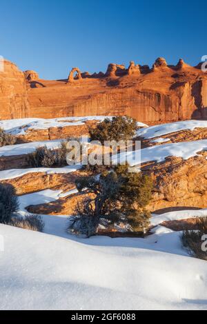 Delicate Arch vom Delicate Arch Viewpoint bei Sonnenaufgang mit Schnee im Winter, Arches National Park, Utah Stockfoto