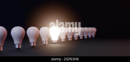 Glühende Glühbirne auf hell zwischen anderen auf dunklem Hintergrund, Führung, große Idee, elektrische Energie, Minimal Glühbirne unter vielen Wendungen Stockfoto