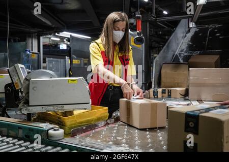 19. August 2021, Baden-Württemberg, Köngen: Adriana Tec, Dispatcher im DHL Paketzentrum in Köngen, scannt während ihrer Nachtschicht Barcodes auf Pakete. (An dpa: 'Hohes Paketvolumen im DHL-Distributionszentrum - Corona oder nicht') Foto: Christoph Schmidt/dpa Stockfoto