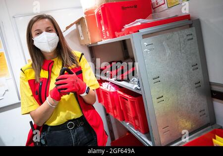 19. August 2021, Baden-Württemberg, Köngen: Adriana Tec, Dispatcher im DHL Paketzentrum in Köngen, zieht zu Beginn ihrer Nachtschicht Arbeitshandschuhe an. (An dpa: 'Hohes Paketvolumen im DHL-Distributionszentrum - Corona oder nicht') Foto: Christoph Schmidt/dpa Stockfoto