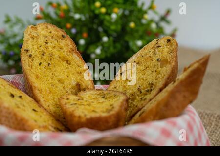 Nahaufnahme von Knoblauchbrotscheiben in einem Rattankorb. Selektive Fokuspunkte. Unscharfer Hintergrund Stockfoto