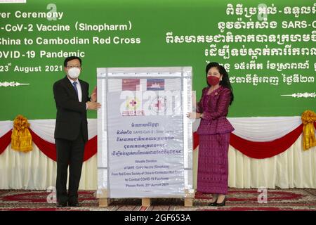 Phnom Penh, Internationaler Flughafen Phnom Penh in Phnom Penh. August 2021. Der chinesische Botschafter in Kambodscha, Wang Wentian (L), übergibt am 23. August 2021 den von China gestifteten Impfstoff Sinopharm COVID-19 an den Präsidenten des kambodschanischen Roten Kreuzes, Bun Rany, auf dem Internationalen Flughafen von Phnom Penh in Phnom Penh, Kambodscha. China spendete am Montag zusätzliche 600,000 Dosen des Sinopharm-Impfstoffs COVID-19 an Kambodscha, was dem südostasiatischen Land einen weiteren Schub für sein Impfprogramm gab. Quelle: Pearum/Xinhua/Alamy Live News Stockfoto