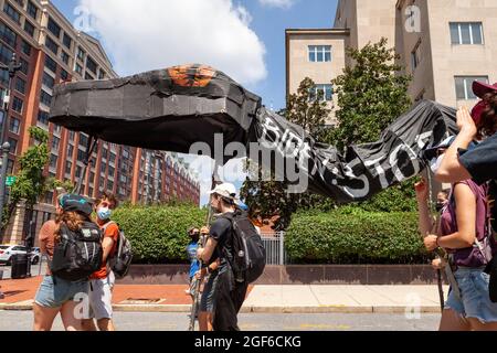 Washington, DC, USA, 23. August 2021. Im Bild: Die schwarze Schlange, die zerstörerische Ölpipelines symbolisiert, verlässt das Hauptquartier des US Army Corps of Engineers während eines marsches gegen Enbridge's Line 3 Ölpipeline, die von Shut Down DC und Extinction Rebellion gesponsert wird. Die Pipeline verläuft durch Vertragsgebiete und das Quellgebiet des Mississippi River, um Ölsand aus Kanada zu transportieren. Die ökologischen und klimatischen Auswirkungen in den nächsten 50 Jahren werden mit dem Bau und Betrieb von 50 Kohlekraftwerken vergleichbar sein. Kredit: Allison Bailey / Alamy Live Nachrichten Stockfoto