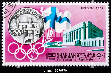 SHARJAH - UM 1968: Eine in den Vereinigten Arabischen Emiraten von Sharjah gedruckte Marke zeigt die Olympischen Spiele Helsinki 1952, Schweden, Geschichte der Olympischen Spiele, um 1968 Stockfoto