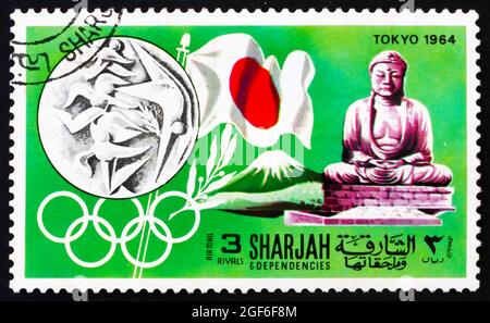 SHARJAH - UM 1968: Eine in den Vereinigten Arabischen Emiraten von Sharjah gedruckte Marke zeigt die Olympischen Spiele Tokio 1964, Japan, Geschichte der Olympischen Spiele, um 1968 Stockfoto