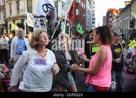 London, Großbritannien. August 2021. Während der Demonstration werden Aktivisten getanzt, während sie die Straße blockieren. Protestler vom Extinction Rebellion engagieren sich im Rahmen des „Impossible Rebellion“ in einem gewaltfreien zivilen Massenungehorsam. Sie saßen zusammen auf der Straße und forderten die Regierung auf, ihre Politik zu ändern, dann die ökologische und klimatische Notlage anzugehen und sofort alle Investitionen in neue fossile Brennstoffe zu stoppen. (Foto von Martin Pope/SOPA Images/Sipa USA) Quelle: SIPA USA/Alamy Live News Stockfoto