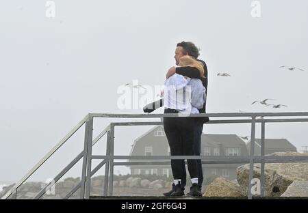 Maine, Usa. August 2021. Ein Mann schützt seine Tochter vor starken Winden und Sand, während er am Strand von Kennebunk den Sturm Henri fotografiert. Kredit: SOPA Images Limited/Alamy Live Nachrichten Stockfoto