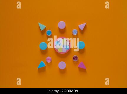 Flache Komposition mit Kosmetikprodukten auf orangefarbenem Hintergrund. Bunte Schwämme. Selbstversorgung von Frauen. Draufsicht Stockfoto