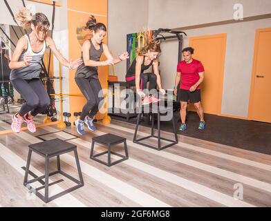 Athleten Frauen tun Box Sprünge im Fitnessstudio Stockfoto