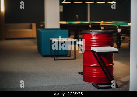 Tisch und zwei Stühle in der Nähe des grünen Billardtisches mit Bällen im Billardclub. Stockfoto