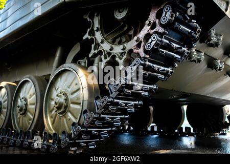 Nahaufnahme der Panzerung. Schwarze Verbindungsbahnen und große gummierte Rollen. Fahrgestell eines Infanteriekampffahrzeugs Stockfoto