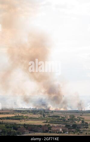 Feuerlöschhubschrauber kämpft mit Sommerbrand in der Toskana, Italien, von Castiglion Fiorentino aus gesehen, 21/08/2021 Stockfoto