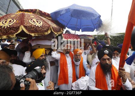 Mitglieder von Sikh riligion tragen am 24. August 2021 3 Saroops von Sri Guru Granth Sahib, der heiligen Schrift, auf dem IGI-Flughafen in Neu-Delhi, Indien. Foto von Anshuman Akash/ABACAPRESS.COM Quelle: Abaca Press/Alamy Live News Stockfoto