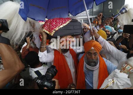 Mitglieder von Sikh riligion tragen am 24. August 2021 3 Saroops von Sri Guru Granth Sahib, der heiligen Schrift, auf dem IGI-Flughafen in Neu-Delhi, Indien. Foto von Anshuman Akash/ABACAPRESS.COM Quelle: Abaca Press/Alamy Live News Stockfoto