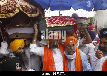 Mitglieder von Sikh riligion tragen am 24. August 2021 3 Saroops von Sri Guru Granth Sahib, der heiligen Schrift, auf dem IGI-Flughafen in Neu-Delhi, Indien. Foto von Anshuman Akash/ABACAPRESS.COM Quelle: Abaca Press/Alamy Live News Stockfoto