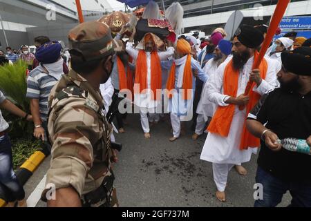 Mitglieder von Sikh riligion tragen am 24. August 2021 3 Saroops von Sri Guru Granth Sahib, der heiligen Schrift in schwerer Sicherheit von CISF-Beamten auf dem IGI-Flughafen in Neu-Delhi, Indien, T3. Foto von Anshuman Akash/ABACAPRESS.COM Quelle: Abaca Press/Alamy Live News Stockfoto