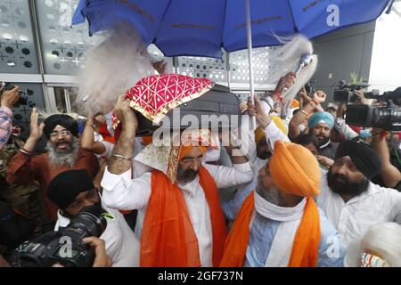 Mitglieder von Sikh riligion tragen am 24. August 2021 3 Saroops von Sri Guru Granth Sahib, der heiligen Schrift, auf dem IGI-Flughafen in Neu-Delhi, Indien. Foto von Anshuman Akash/ABACAPRESS.COM Quelle: Abaca Press/Alamy Live News Stockfoto