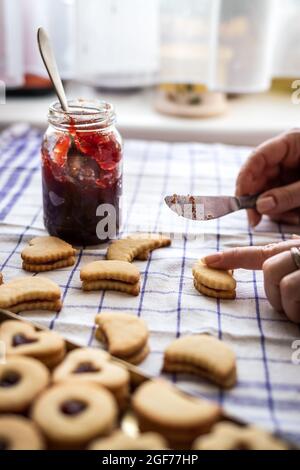 Kochen Linzer Cookies. Von Hand gebackenes Gebäck mit Marmelade zubereiten und füllen. Traditionelle hausgemachte Weihnachtsbonbons Stockfoto