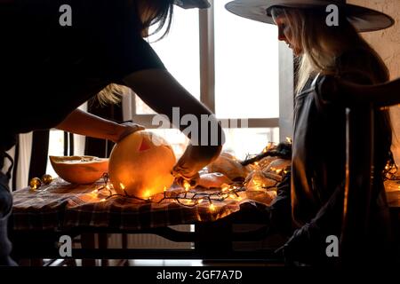 Frau und Kind Mädchen Spaß haben und feiern Halloween in Hexen-Kostüm. Stockfoto