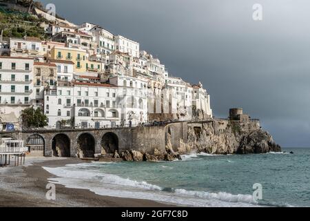 Amalfi, Kampanien, Italien, Februar 2020: Blick auf die schöne Amalfi mit seinem Strand. Dunkler Himmel mit eintreffendem Gewitter. Amalfiküste Stockfoto