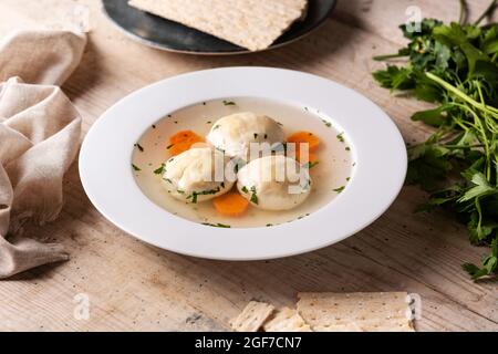 Traditionelle jüdische Matzoballsuppe auf Holztisch Stockfoto