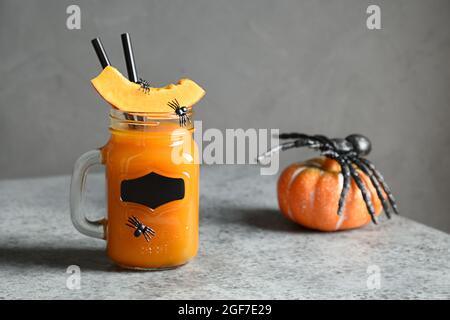 Halloween Kürbis Cocktails für festliche Party auf grauem Hintergrund mit Spinnennetz. Nahaufnahme. Stockfoto