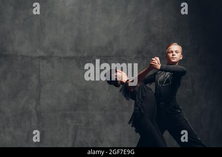 Kombinieren Sie Tango-Tänzer in schwarzen Kostümen, die im Ballsaal tanzen. Stockfoto