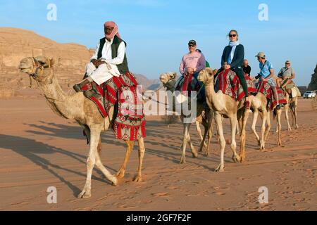 Touristen nehmen an einem geführten Kamelritt auf Dromedary (Camelus dromedarius), Dromedary, Wadi Rum und Jordanien Stockfoto