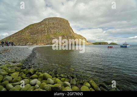 Besucher auf einem Tagesausflug zu den Shiant Isles, die auf der felsigen Landenge ankommen, die Garbh Eilean und Eileen an Taighe verbindet. Stockfoto