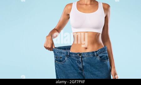 Nahaufnahme Einer Frau, Die Ihre Alte Große Lose Jeans Zieht Stockfoto