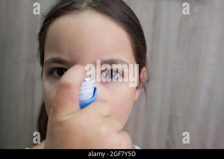 Kind Mädchen mit medizinischen Spray für den Atem. Inhalator. Vorderansicht Stockfoto