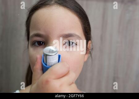 Kind Mädchen mit medizinischen Spray für den Atem. Inhalator. Vorderansicht Stockfoto