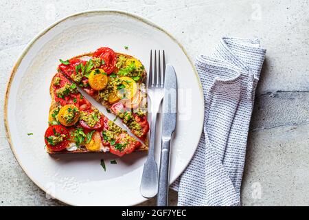 Toast mit Tomaten, Pesto-Sauce und Frischkäse, Draufsicht. Italienisches Küchenkonzept. Stockfoto